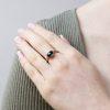 Oval cabochon blue tourmaline set in fairtrade 18ct white gold, shown on model.