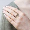 Cone ring with olive green diamond in platinum, shown on model.