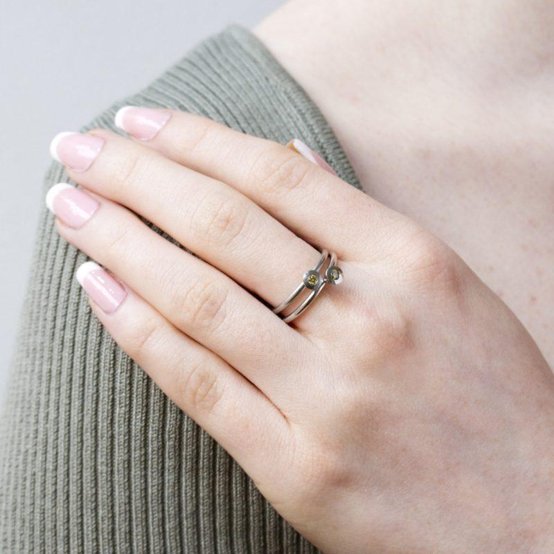 Cone ring with olive green diamond in platinum, shown on model.