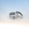 Two sterling silver rings from Force of Nature Collection - wider band and narrower band with parallel layered grooved patterns against soft blue background.