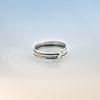 Modern silver wrap ring from the Force of Nature collection, featuring a layered band design, handcrafted in sterling silver and photographed on a soft gradient background.