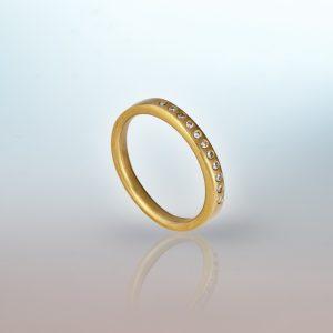 18ct yellow gold ring with eleven small round white diamonds set in a row.
