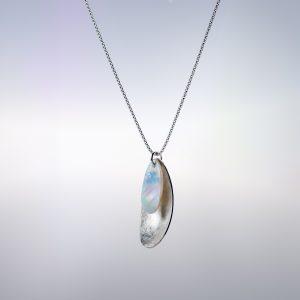 A Silver pedant with a Mother-of-Pearl shape nestled into the silver shape