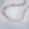 Faceted Pink Pearl Necklace laying down in a curved shape
